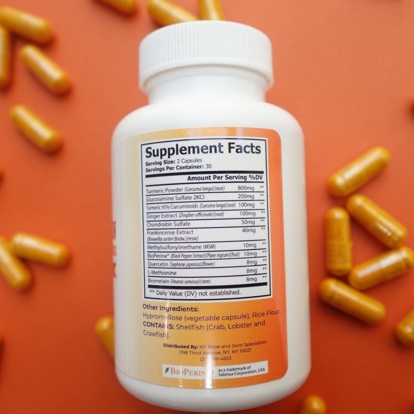 Supplement bottle with capsules on an orange background