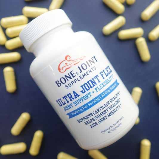 Bottle of Bone & Joint supplement with scattered capsules on a dark background